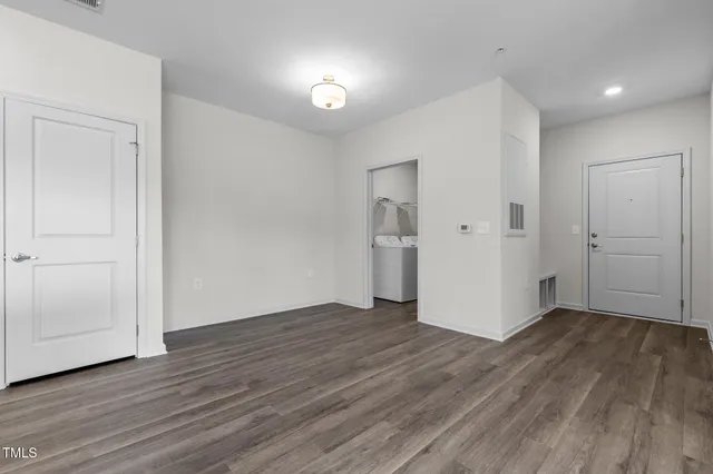 an empty room with wooden floor & closet area
