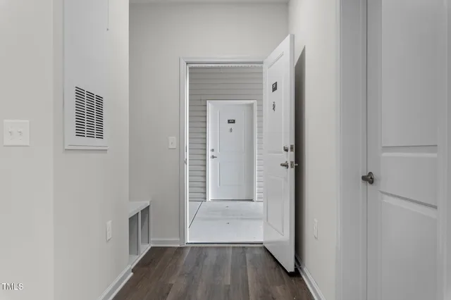 a view of a hallway with wooden floor and closet