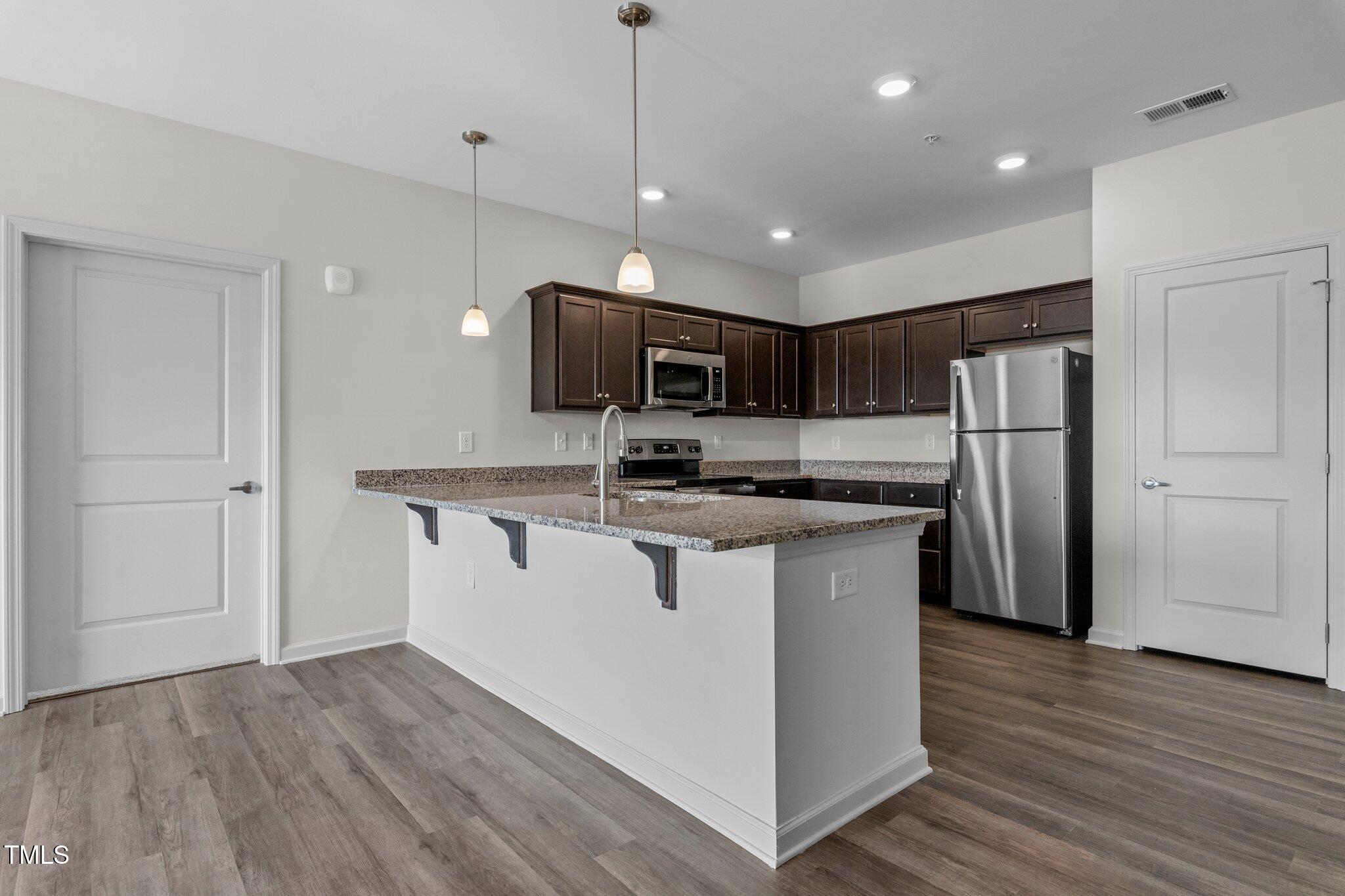 170 Grove Circle, Unit 302 Lillington, NC 27546 - Photo 8 of 28 a kitchen with stainless steel appliances granite countertop a refrigerator a stove a sink and a microwave