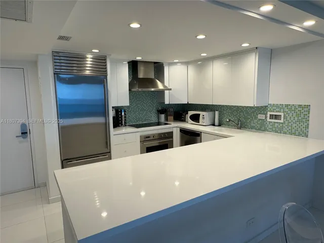 a kitchen with stainless steel appliances a refrigerator sink and microwave