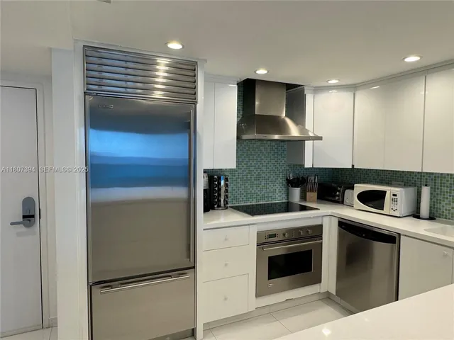 a kitchen with a refrigerator sink and cabinets