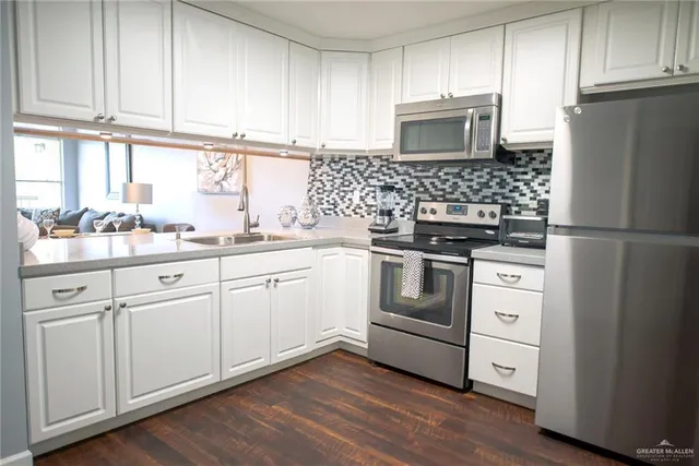 a kitchen with white cabinets and white appliances