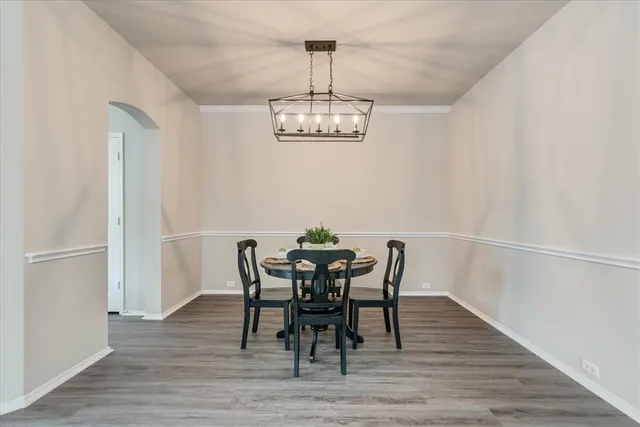 a view of a dining room with furniture a chandelier and wooden floor