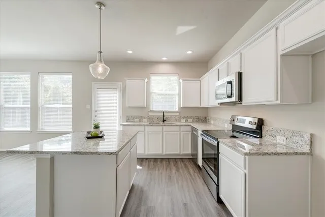 a kitchen with granite countertop white cabinets and white appliances