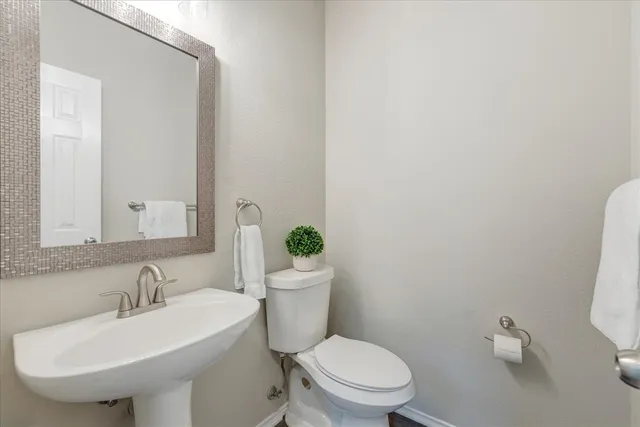 a bathroom with a sink a toilet and a mirror
