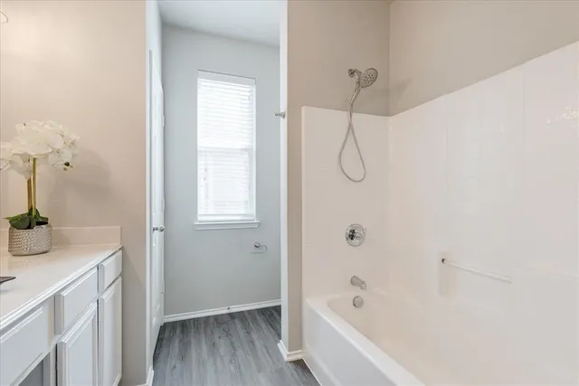 a bathroom with a granite countertop sink a vanity and shower