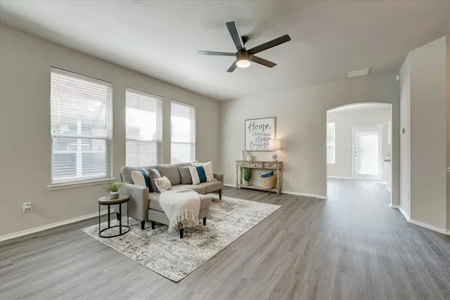 a living room with furniture and a wooden floor