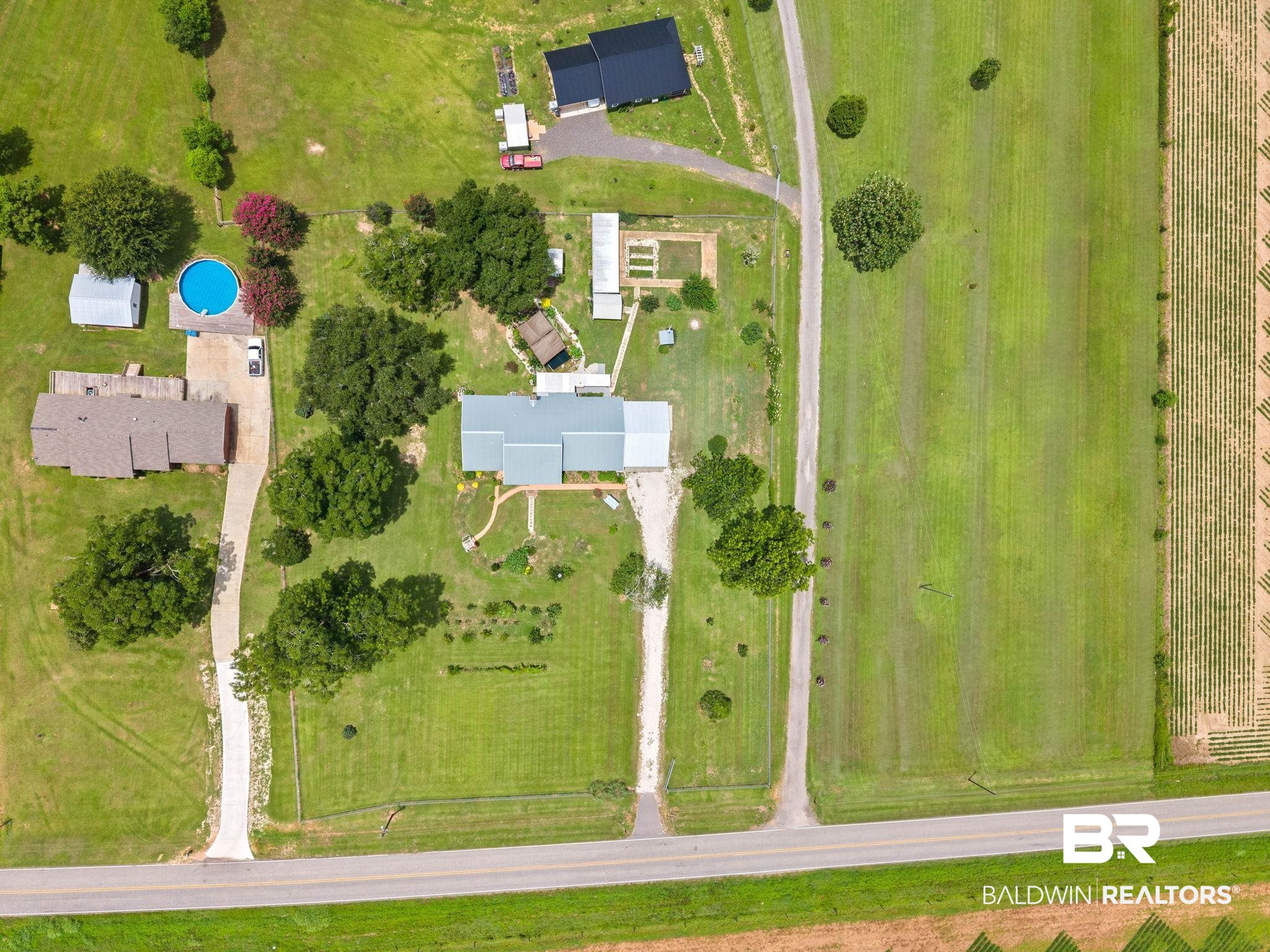 3791 Robinsonville Road Atmore, AL 36502 - Photo 55 of 55 Expansive property featuring two distinct residential structures with light-colored roofs, surrounded by lush green lawns and mature trees