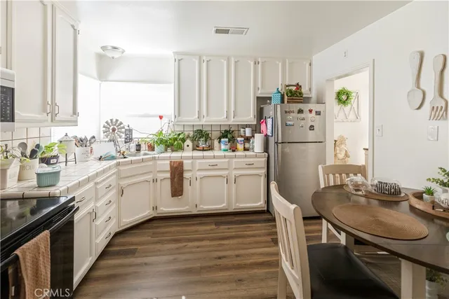 a kitchen with white cabinets and white appliances