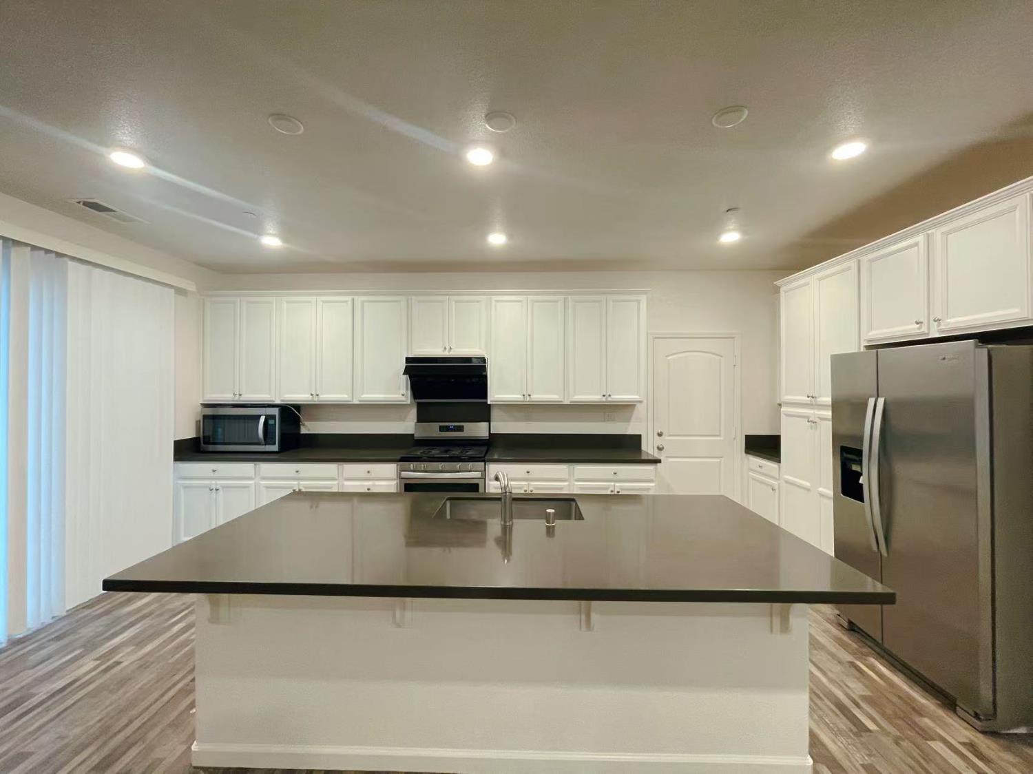 3781 Samuelson Way Sacramento, CA 95834 - Photo 13 of 42 a kitchen with kitchen island a stove a sink and a refrigerator