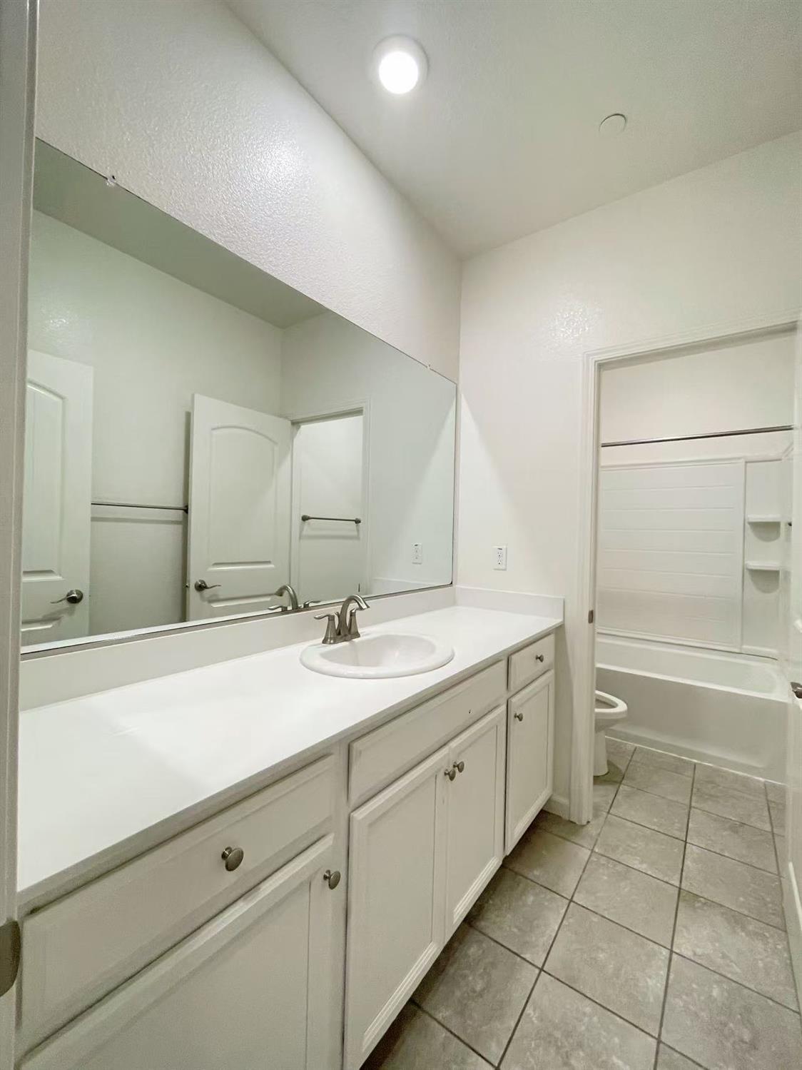 3781 Samuelson Way Sacramento, CA 95834 - Photo 25 of 42 a spacious bathroom with a granite countertop sink a mirror and a bathtub