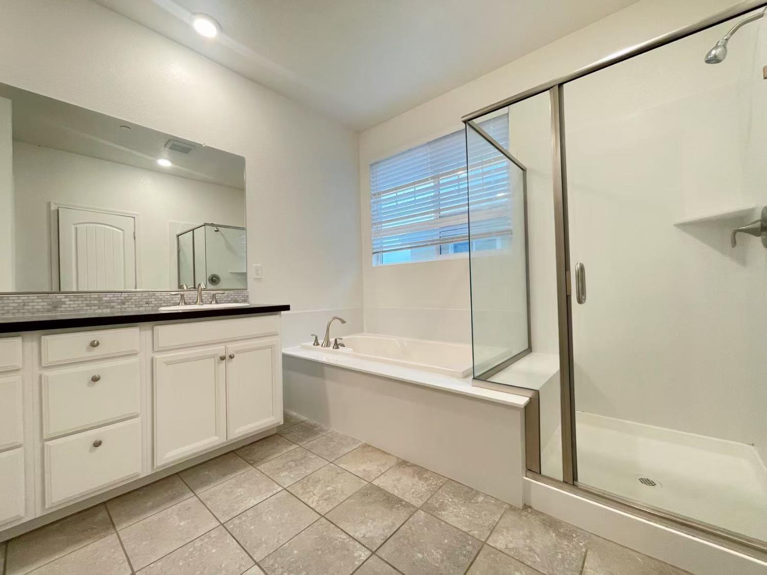 3781 Samuelson Way Sacramento, CA 95834 - Photo 29 of 42 a spacious bathroom with a granite countertop sink a mirror and a bathtub