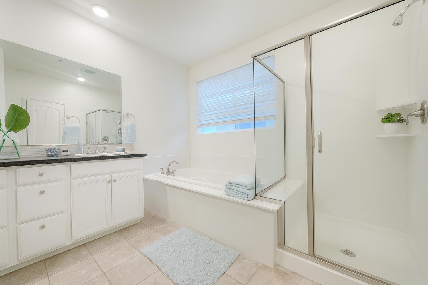 3781 Samuelson Way Sacramento, CA 95834 - Photo 30 of 42 a spacious bathroom with a granite countertop sink a mirror and a bathtub