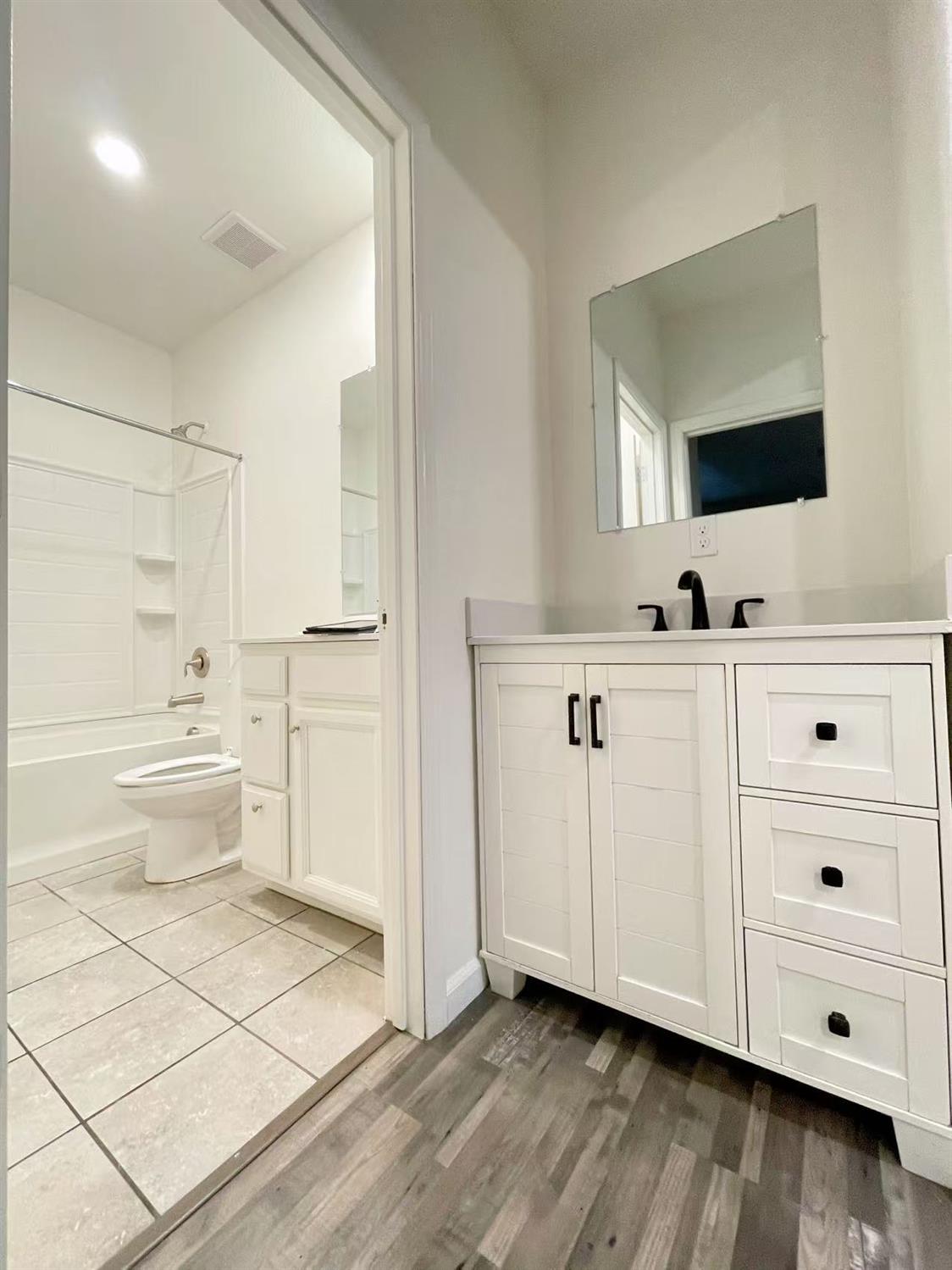 3781 Samuelson Way Sacramento, CA 95834 - Photo 5 of 42 a large white bathroom with a double vanity sink a mirror and a bathtub