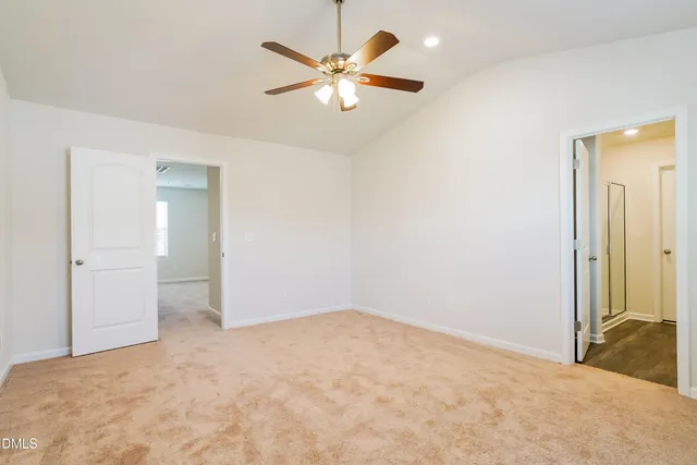 an empty room with closet and fan