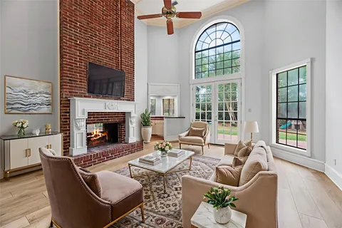 a living room with furniture a fireplace and a floor to ceiling window