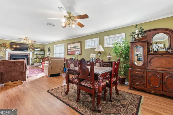 a view of a dining room with furniture a chandelier and wooden floor
