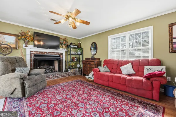 a living room with furniture a fireplace and a flat screen tv