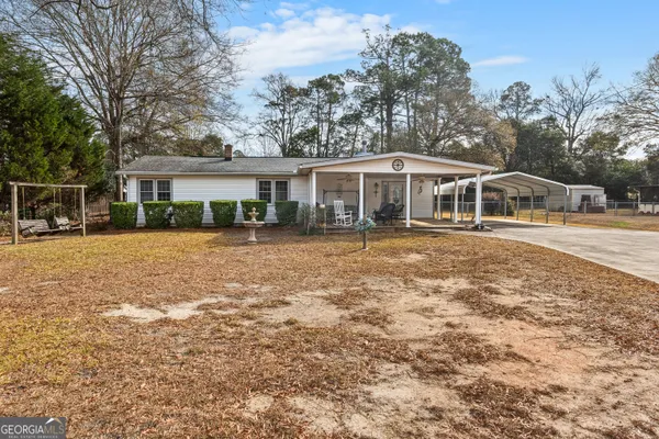 a front view of a house with a yard tree and wooden fence