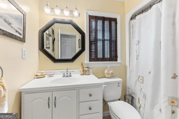 a bathroom with a toilet a sink and a mirror