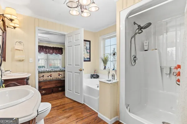 a bathroom with a tub shower sink and mirror