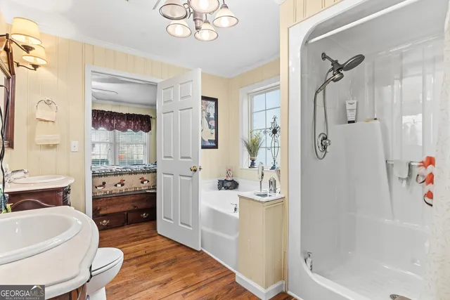 a bathroom with a tub shower sink and mirror