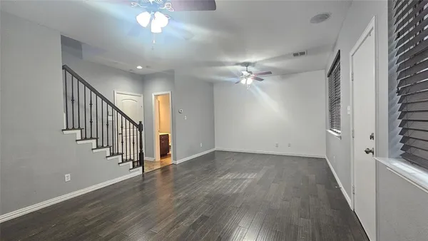 a view of a hallway with wooden floor and staircase