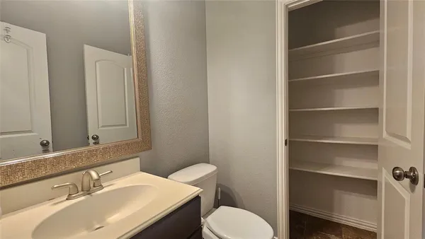 a bathroom with a sink vanity mirror and toilet