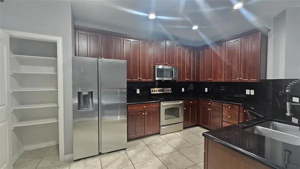 a kitchen with kitchen island granite countertop wooden cabinets and stainless steel appliances