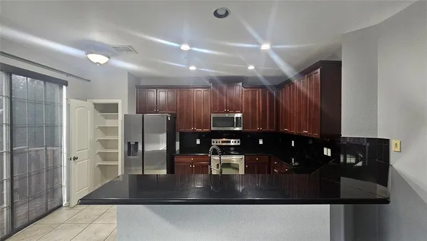 a kitchen with refrigerator and window