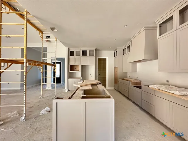 a kitchen with stainless steel appliances kitchen island granite countertop a sink stove and cabinets