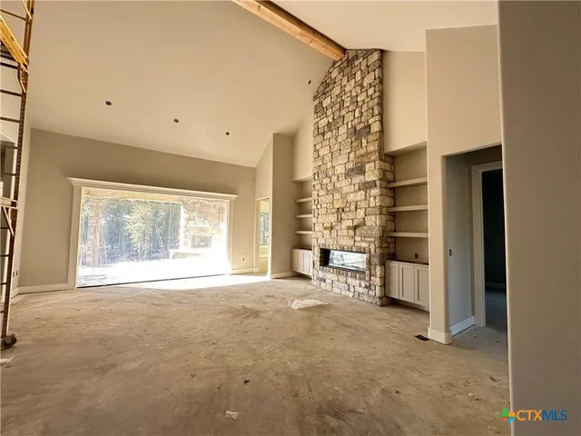 a view of an empty room with a fireplace and a window