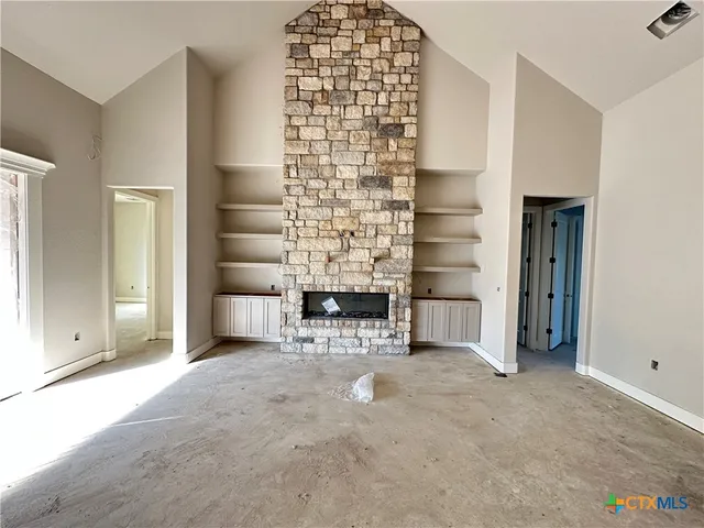 an empty room with a fireplace and cabinet