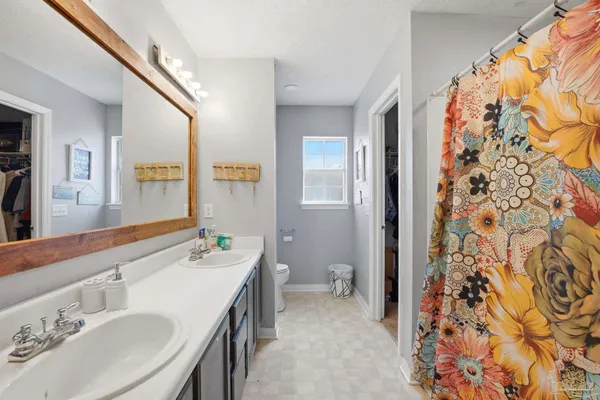 a spacious bathroom with a double vanity sink mirror and shower