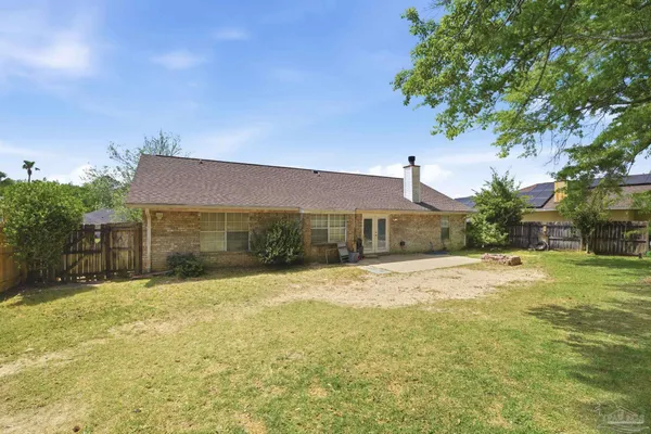a front view of house with yard and trees in the background