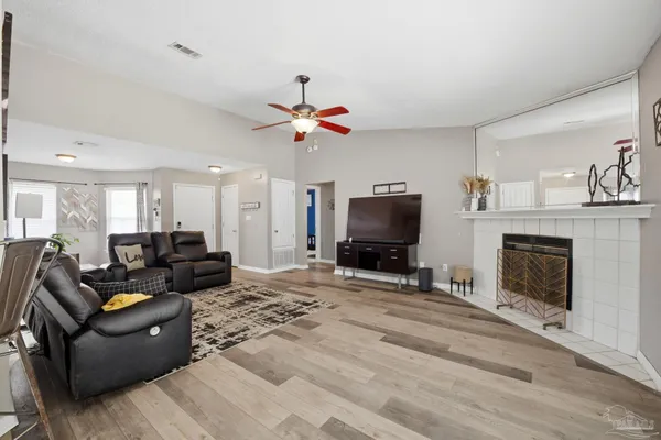 a living room with furniture a fireplace and a flat screen tv