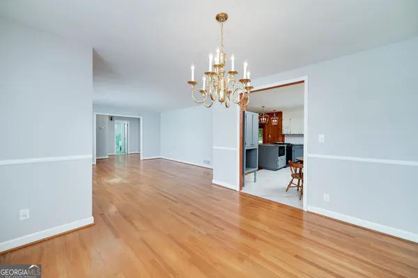 a view of a livingroom with wooden floor and kitchen space