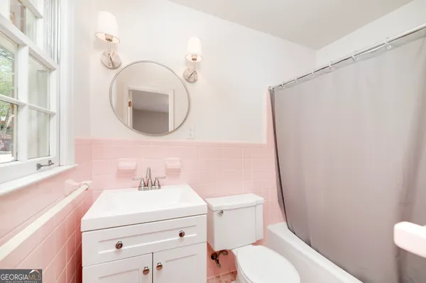 a bathroom with a sink a toilet and a mirror
