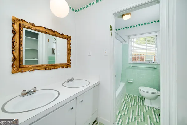 a bathroom with a granite countertop sink a toilet and a mirror