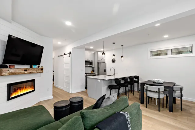 a living room with furniture flat screen tv and kitchen view