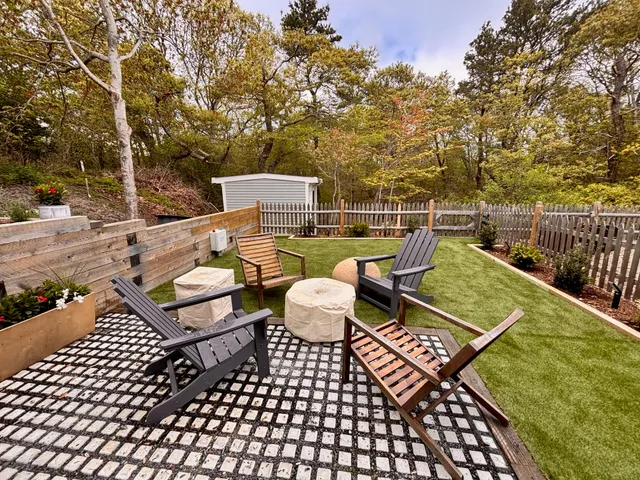a view of a roof deck with couches and wooden fence