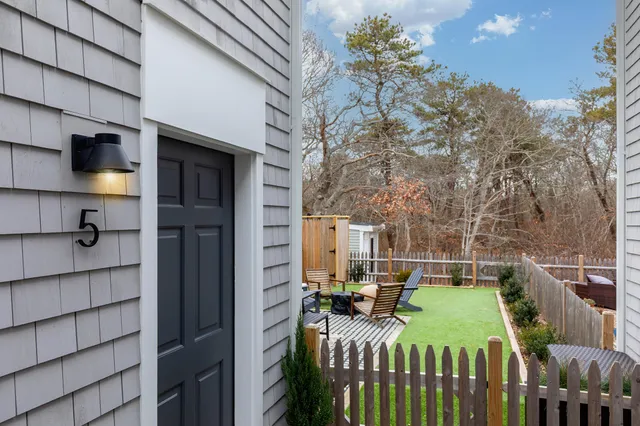 a view of a patio with table and chairs with wooden fence and plants