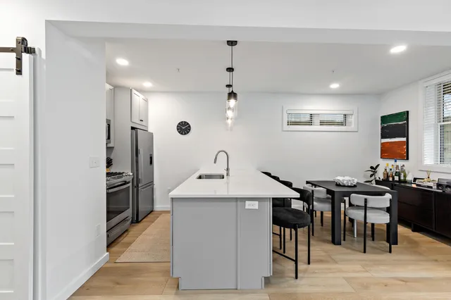 a kitchen with stainless steel appliances kitchen island granite countertop a sink and a refrigerator