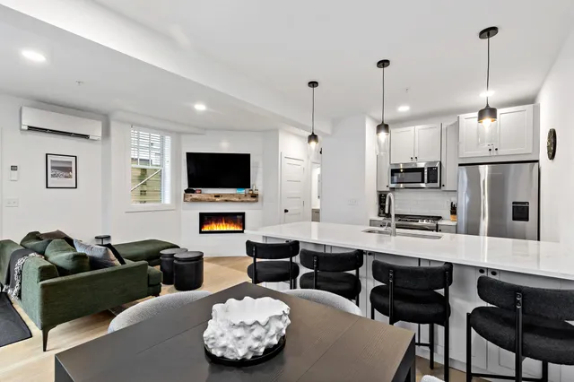 a living room with furniture kitchen view and a flat screen tv