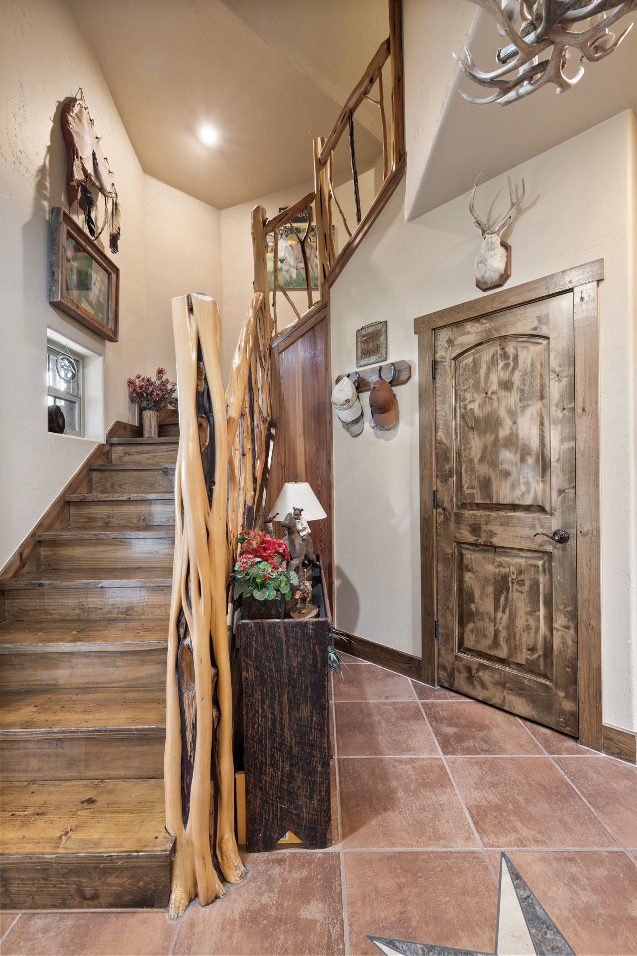 8400 Ranch Road 1431 Marble Falls, TX 78654 - Photo 27 of 30 A rustic staircase with natural wood railings leads to an upper level, complementing the warm tiled flooring below.