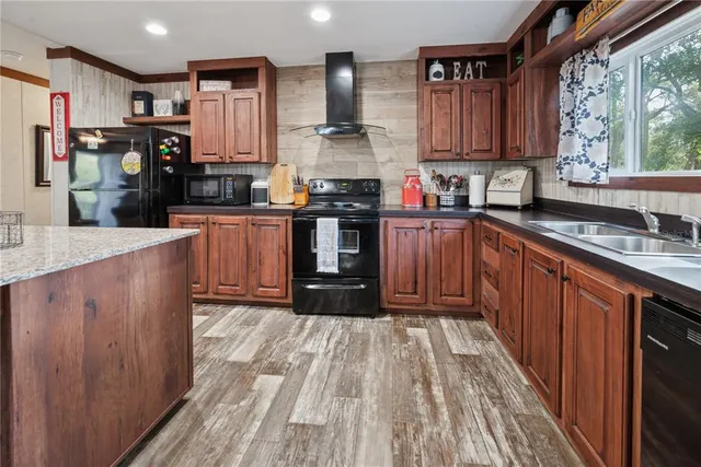 a kitchen with stainless steel appliances granite countertop a stove a sink dishwasher and a refrigerator