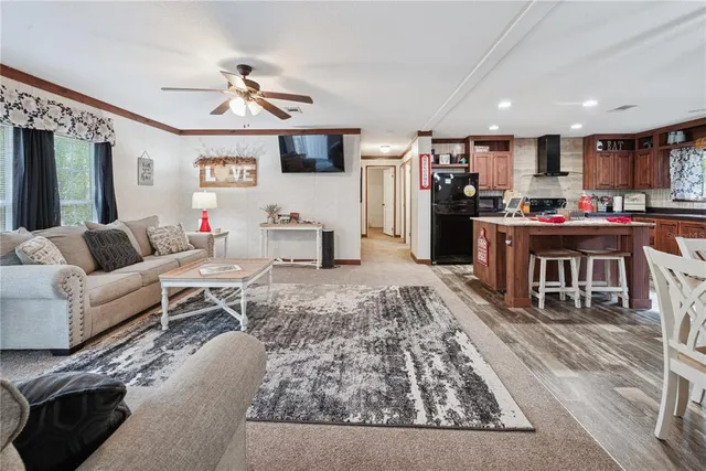 a living room with furniture appliances and a open kitchen view