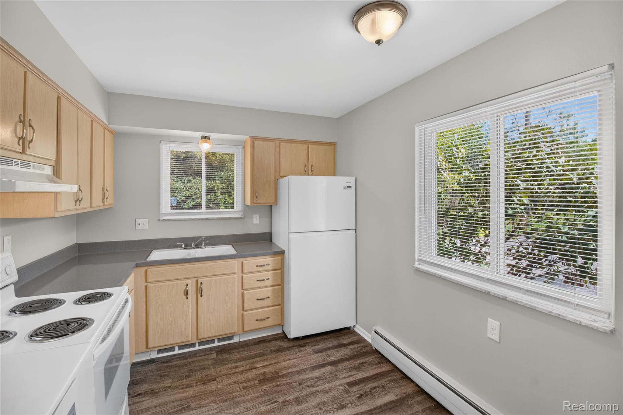 22000 Beck Road, Unit 101 Northville, MI 48167 - Photo 7 of 20 Kitchen featuring wood-finish cabinetry, solid surface countertops, a white top-freezer refrigerator, and a white electric range