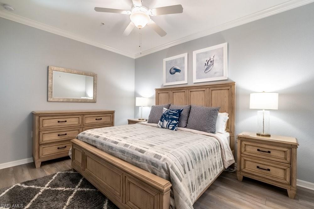 9578 Trevi Court, Unit 5142 Naples, FL 34113 - Photo 12 of 49 a bedroom with a bed and a chandelier