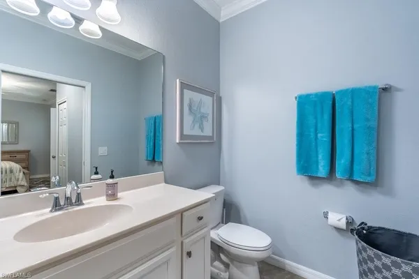 a bathroom with a granite countertop sink and a toilet